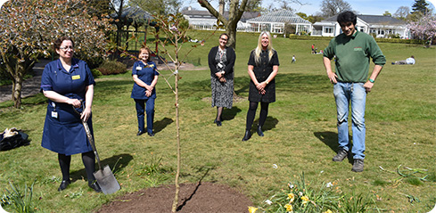 Image: Margaret Garbett, Director of Nursing; Dawn Chaplin, Deputy Director of Bereavement and End of Life Care; Susan Price, Deputy Director of Inclusion, Health and Wellbeing and Social Cohesion; and Sally Lawson, Head of Inclusion, Wellbeing, Partnerships and Events attending the planting of the tree