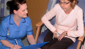 A nurse talks to a patient during a Care Round visit