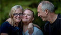 Image: Two parents/carers and a young man