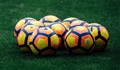 Footballs grouped together on grass