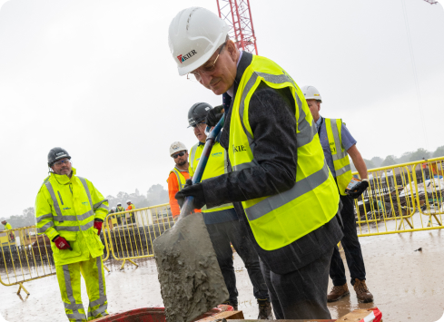 Professor David Rosser adding the final shovel of cement to the ACAD building