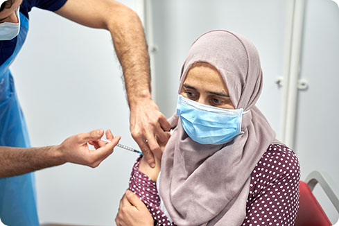 A healthcare worker administers a COVID vaccine to a patient