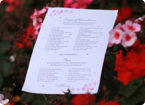A poem printed on paper laid on top of a bed of flowers