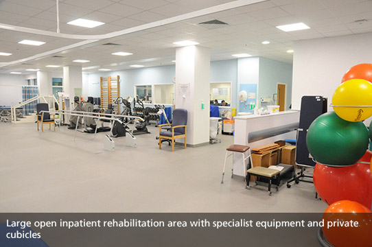 Large open inpatient rehabilitation area with specialist equipment and private cublicles